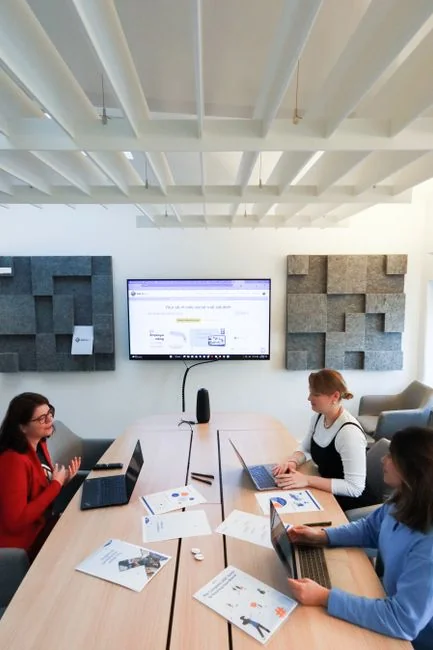 Team reviewing financial charts and digital data on tablets in an office setting.